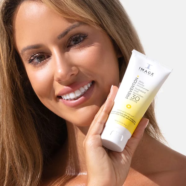 IMAGE PREVENTION+® daily matte moisturizer SPF 30 front view being held by smiling woman